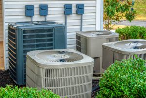 Residential HVAC units outside a home affected by poor attic insulation