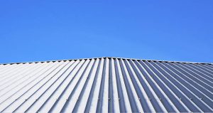 Corrugated metal roof installation in Jacksonville, FL with bright sky overhead