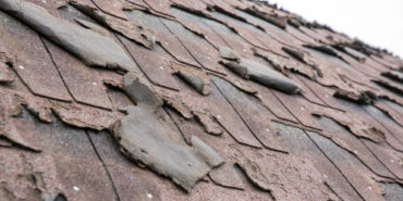 Close-up of old, broken roof shingles — a common cause of roof leaks in Jacksonville homes