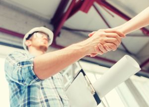 Homeowner shaking hands with roofing contractor, illustrating trust and key questions to ask a roofing contractor before hiring