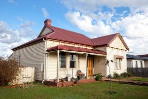 Classic Victorian house with red metal roof – how to tell how old your roof is
