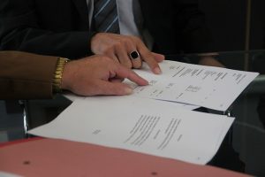 Hands reviewing a roofing contract before signing
