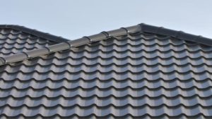 Dark grey corrugated metal roof panels with visible ridges and a clean finished edge.