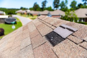 Damaged roof shingles showing common types of storm damage after severe weather