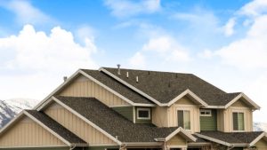 Large house with dark pitched roof showing results of remodel from flat to pitched roof