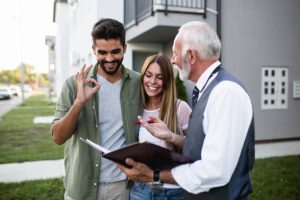 Young couple consulting with roofing contractor about new roof options