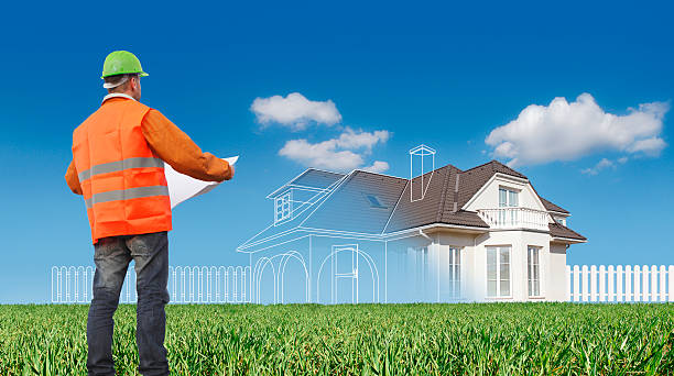 Contractor holding building plans and overseeing new home construction planning for modern roofing trends 2023