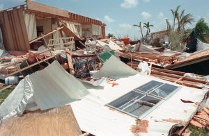 Severe hurricane damage to a Florida home with walls and belongings scattered across the lawn