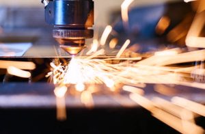 Laser cutting metal roof panel during the metal roof manufacturing process