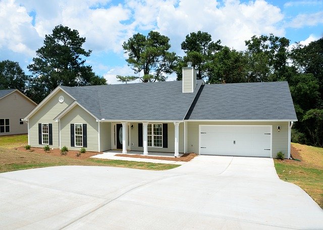 Detached single-family home with white exterior walls and gray shingle roof