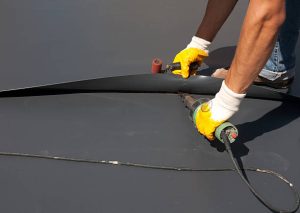 Close-up of professional applying roof coating to a residential roof for energy efficiency and durability