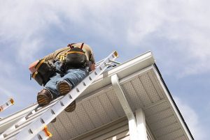 Roofing contractor on ladder preparing for roof repair