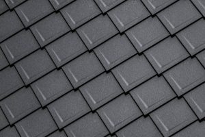Close-up of modern dark grey roofing tiles arranged in a rectangular pattern.