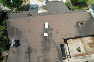 Close aerial view of damaged flat roof seams before metal roof install in Miramar Terrace Duval County