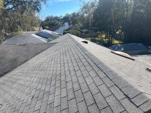 Before photo of a damaged tan shingle roof with granule loss in Atlantic Beach.