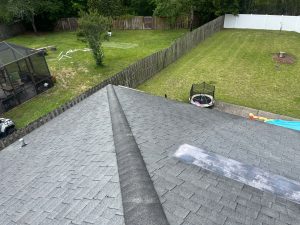 Perfectly aligned Onyx Black ridge cap shingles and roof ventilation system details on a finished roof facet.