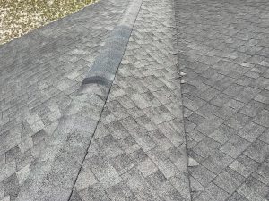 Front exterior perspective of an aging, damaged asphalt shingle roof in Westside Jacksonville FL prior to replacement.
