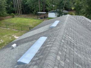 Detailed view of a deteriorated roof valley with curling shingles and organic buildup before Prime Roofing replacement.