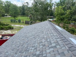 High-angle view of newly installed Williamsburg Gray Owens Corning Duration shingle roof slopes and ridge cap in Westside Jacksonville.